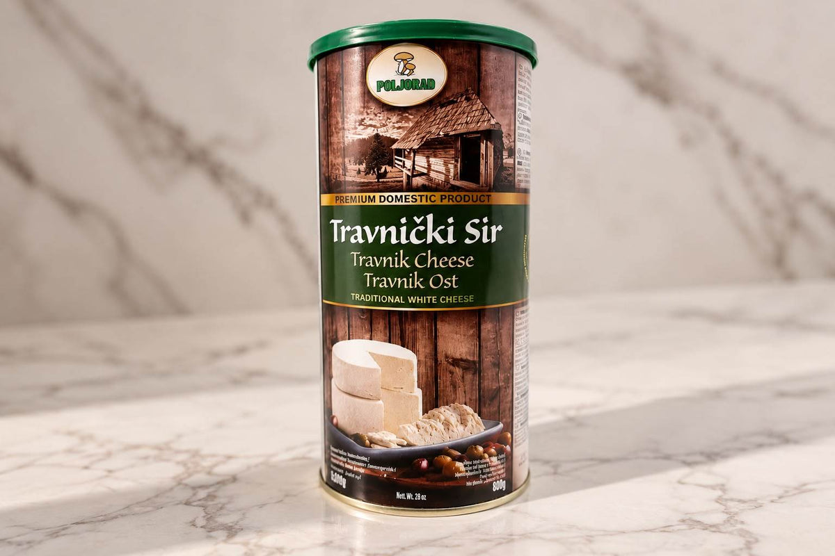 Travnicki Sir Weichkäse in einer zylindrischen Dose mit grünem Deckel und rustikalem Holzmotiv auf dem Etikett